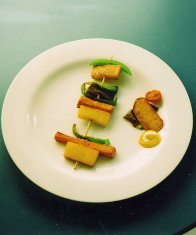 Kirsten Kötter: Vegetarischer Spieß nach Jermolajewa, 2009, Stücke von Kartoffel, Möhre, Lauch, Aubergine (geschmort), auf Holzspieß, mit Dekoration